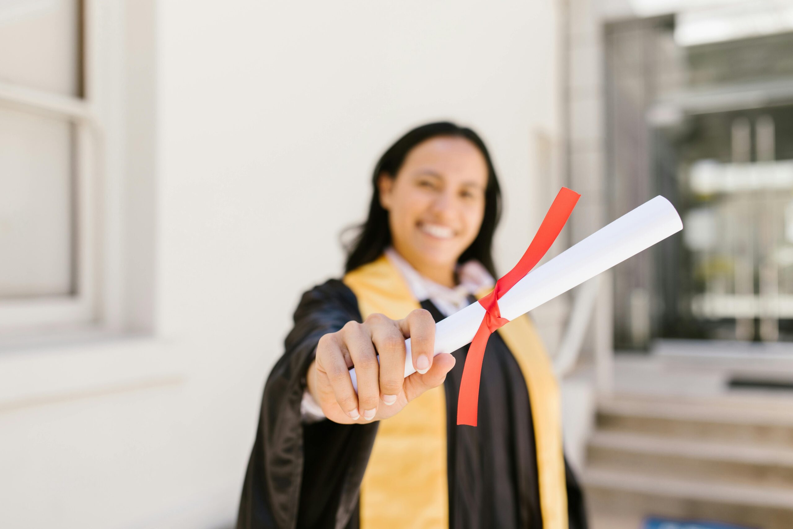 A happy graduate proudly displays her diploma in an outdoor setting, symbolizing achievement.